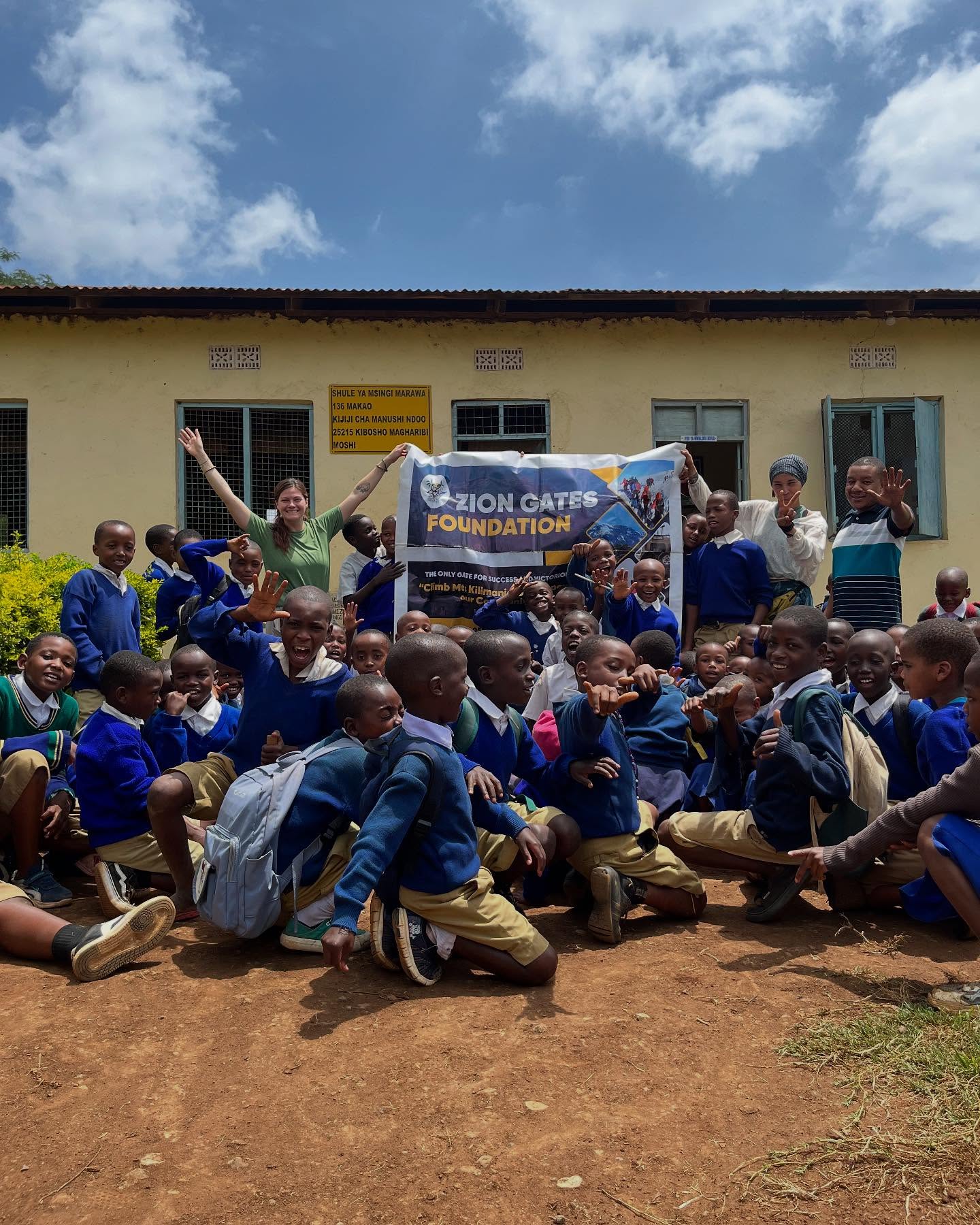 School children and teachers with a Zion Gates banner